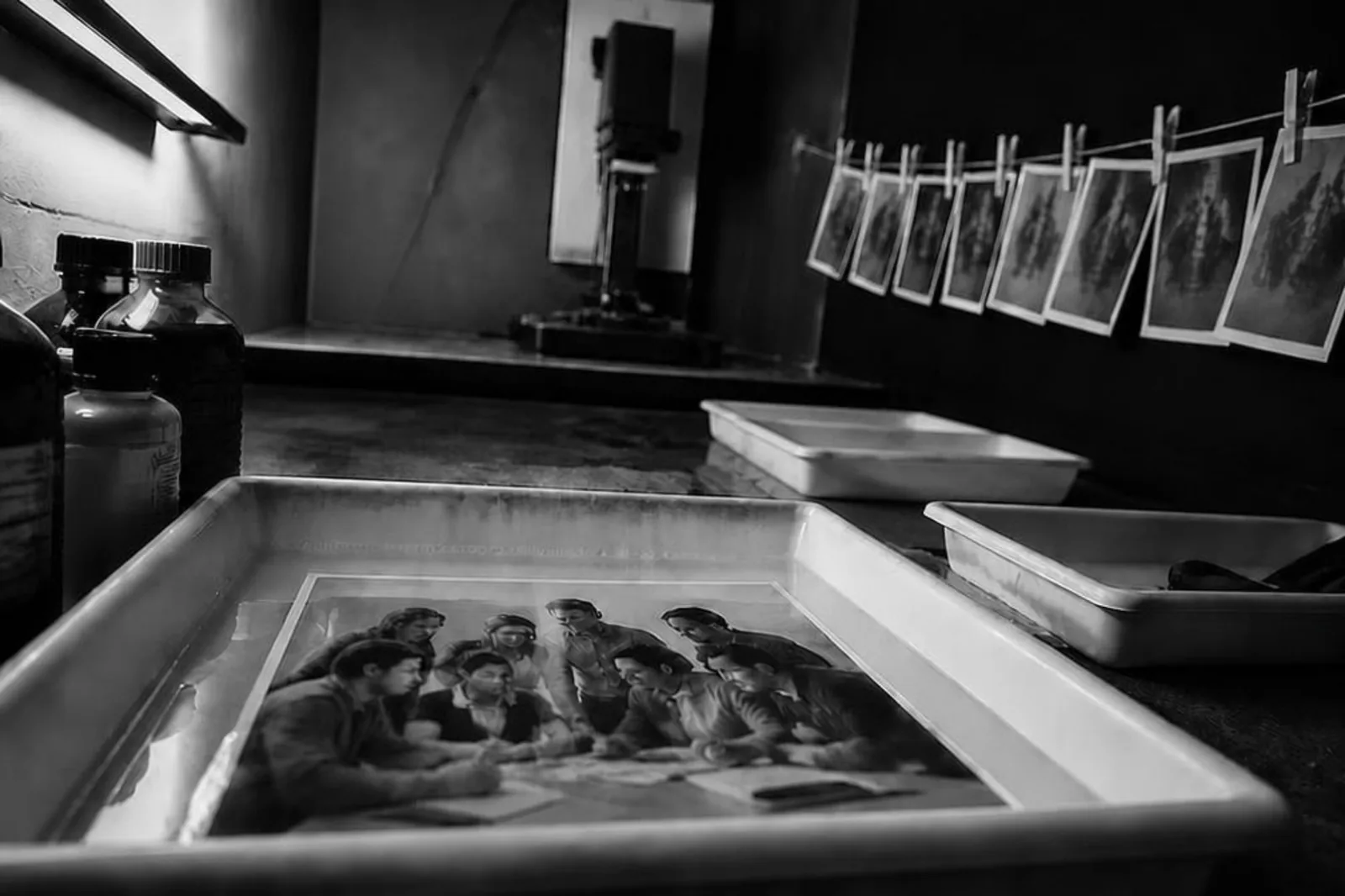 Un tirage photographique révélé dans le bain d'un laboratoire argentique, métaphore de la valeur que l'on rend visible